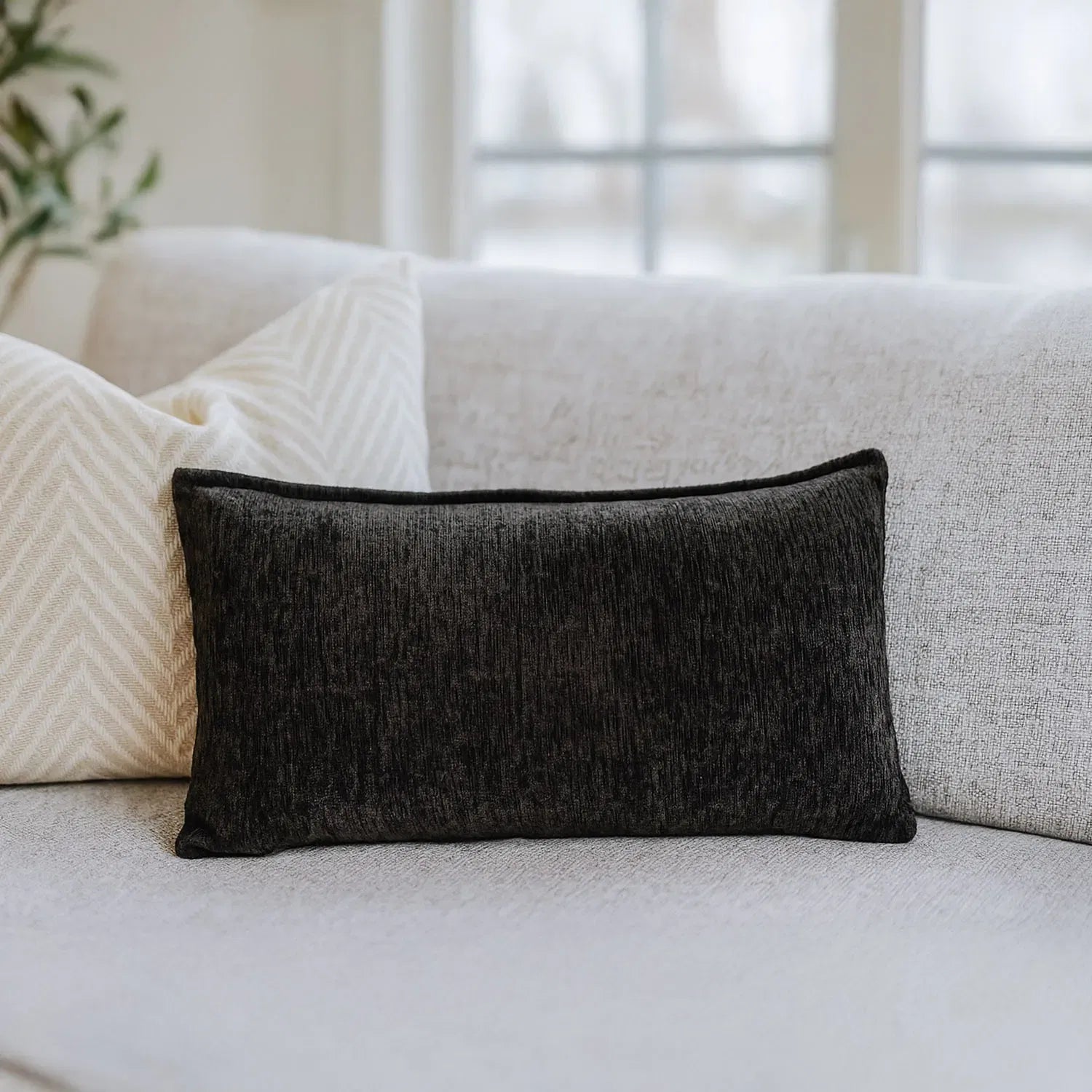 Nourest S1 massage pillow with wireless hot compress, stylish black design on a sofa.