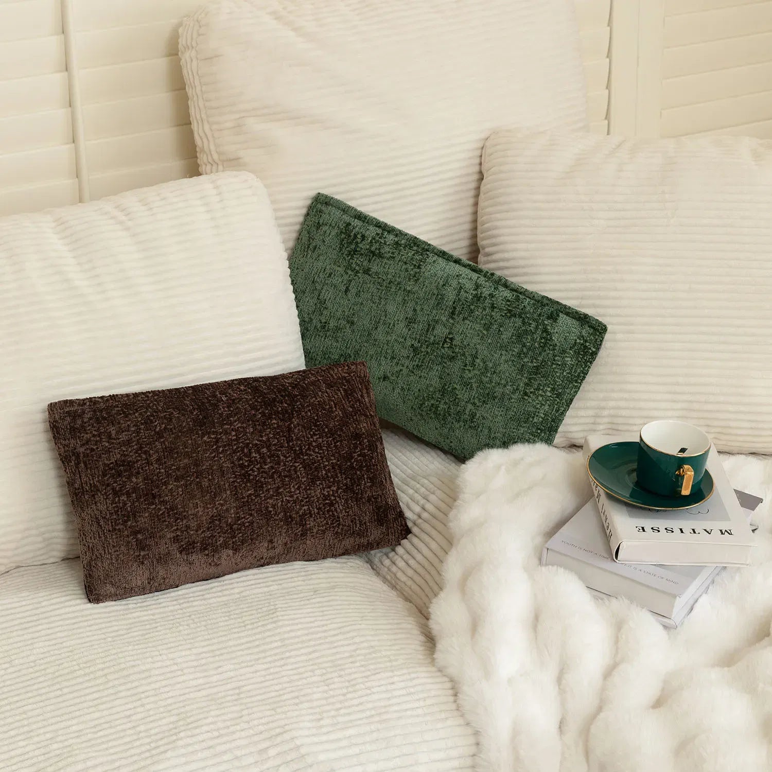 Nourest S1 wireless hot compress massage pillow on a cozy couch with a cup and magazines.