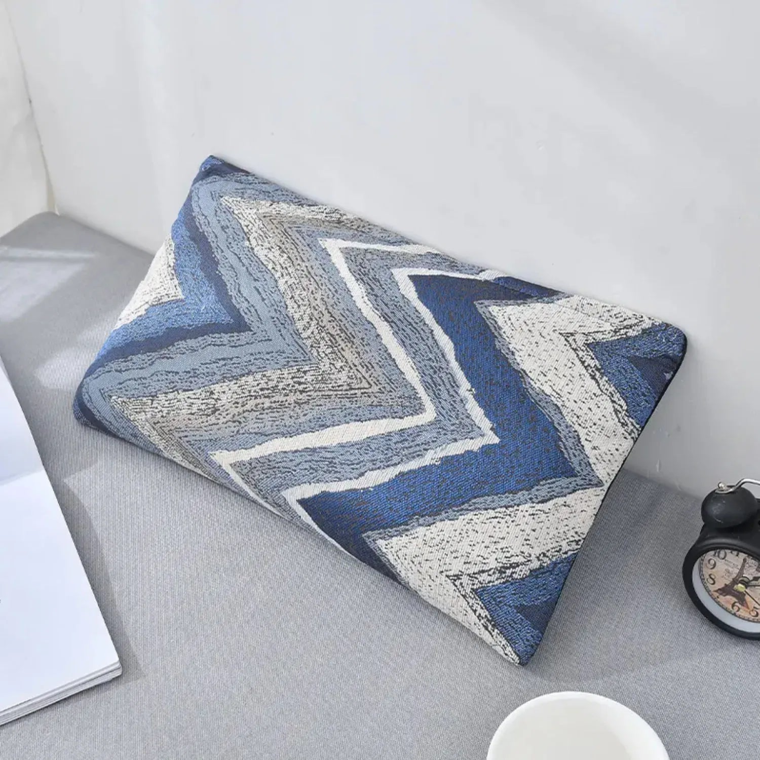 Nourest S1 wireless hot compress massage pillow with a blue and gray zigzag design on a desk.