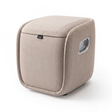 A square, cube-shaped upholstered storage bin or laundry hamper in a light beige fabric, featuring a hinged lid, a small black brand tag on the front, and a recessed handle cutout on the side, set against a plain white background.