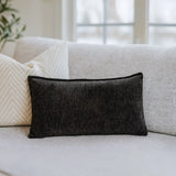 Nourest S1 massage pillow with wireless hot compress, stylish black design on a sofa.