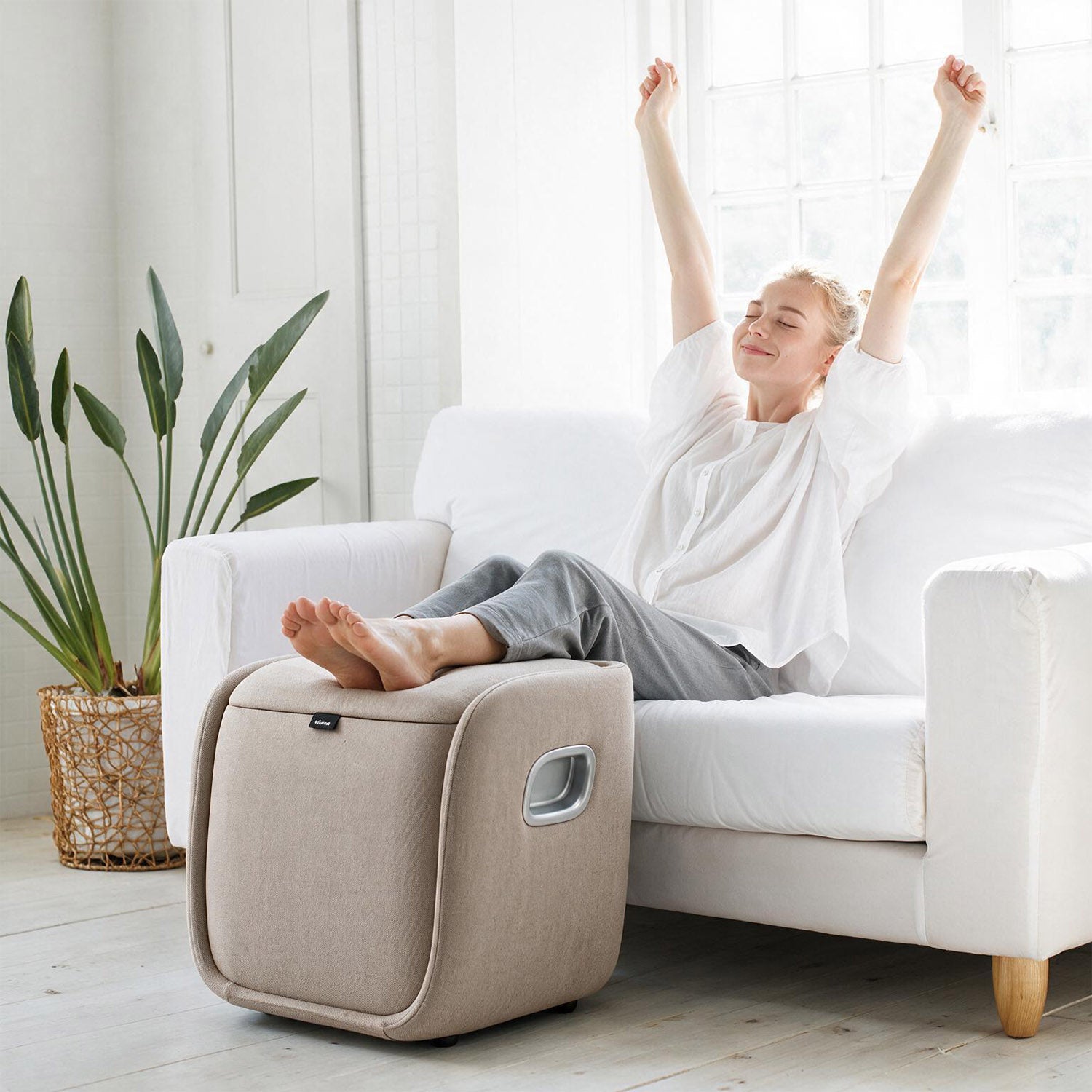 Woman using the detachable wireless massage cover from the Nourest VibeX foot and leg massager